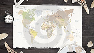 Map of the world on old paper surrounded by compass, anchor, lifebelt and shells