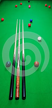 Maple and ebony cues on a snooker table with balls photo
