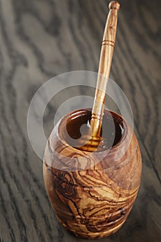 Maple honey flowing from dipper to pot, rustic