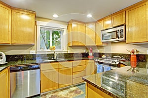 Maple kitchen cabinet with black granite tops