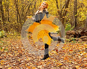 Maple leaf instead of skirt girl in autumn forest a lot of yellow leaves in a leather jacket