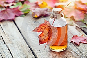 Maple syrup or healthy tincture and maple leaves. photo
