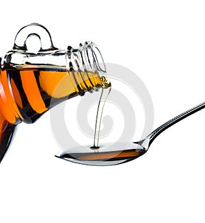 Maple syrup pouring on spoon