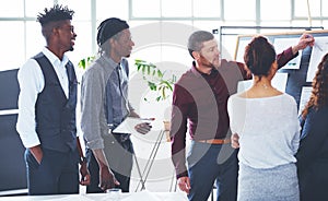 Mapping out the way forward. a group of businesspeople brainstorming in an office.