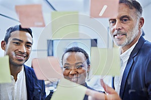 Mapping the way forward with confidence. a group of businesspeople brainstorming with notes on a glass wall in an office