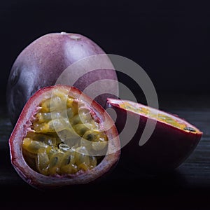 Maracuja (passion-fruit) in moody natural light setting on dark