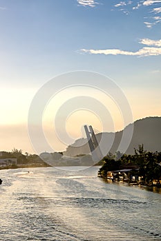 Marapendi Lagoon seen from above with houses on the hill during sunset, golden light. Jet skis are riding on the lake. Barra da Ti