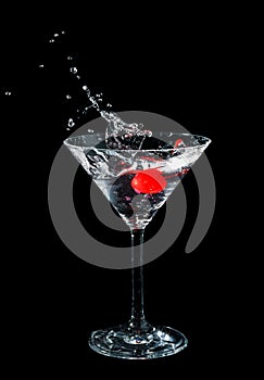 Maraschino cherry dropped in cocktail glass