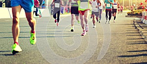 marathon athletes legs running on city road