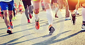 Marathon athletes legs running on city road