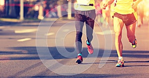 Marathon athletes legs running on city road