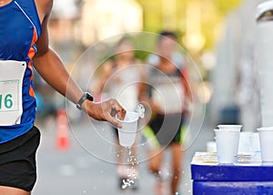 Marathon racer catching cup of water