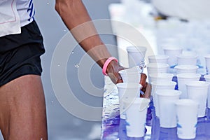 Marathon racer catching cup of water