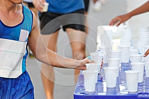 Marathon racer catching cup of water