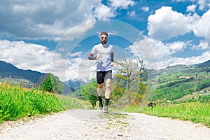 Marathon runner trains in a mountain dirt road