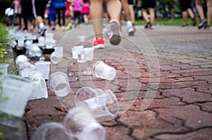 Marathon runners feet and emptry water cups on refreshment point