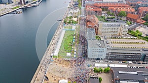 Marathon running race, aerial view of start and finish line with many runners from above, road racing, sport competition