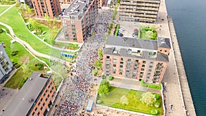 Marathon running race, aerial view of start and finish line with many runners from above, road racing, sport competition