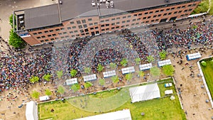 Marathon running race, aerial view of start and finish line with many runners from above, road racing, sport competition