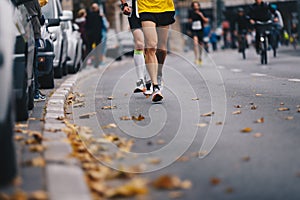 Marathon running race, people feet on autumn road. Runners run uMarathon running race, people feet on autumn road. Runners run urb