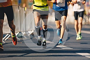 Marathon running race, people feet on autumn road. Runners run urban marathon in the downtown