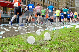 Marathon running race, runners feet and plastic water cups on road near refreshment point, sport, fitness and healthy lifestyle