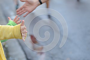 Marathon running race,runners support on road race, child`s hand giving highfive, kid supporting athletes who run