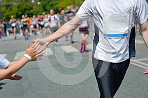 Marathon running race,runners support on road race, child`s hand giving highfive, kid supporting athletes who run