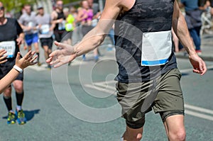 Marathon running race,runners support on road race, child`s hand giving highfive, kid supporting athletes who run