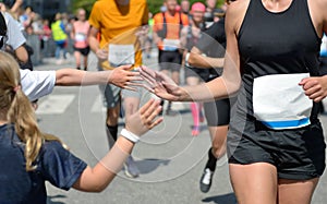 Marathon running race,runners support on road race, child`s hand giving highfive, kid supporting athletes who run