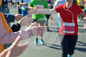 Marathon running race, support runners on road, child`s hand highfive, sport concept
