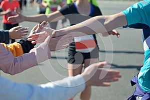 Marathon running race, support runners on road, child`s hand highfive, sport concept