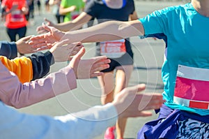 Marathon running race, supporting runners on road, children hands giving highfive