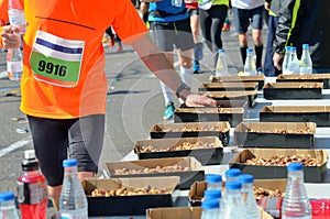 Marathon running road race, runners hand taking food and drinks on refreshment point, sport, fitness and healthy lifestyle photo