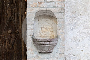 Marble basin for holy water, next to the ancient door.