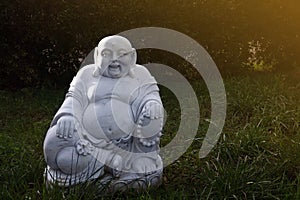 Marble budai hotei in a garden- is a Chinese folkloric deity. Name means `Cloth Sack`, a laughing buddha. Note to the reviewer: photo