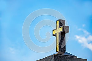 Marble Catholic cross on the background of the sky with light clouds