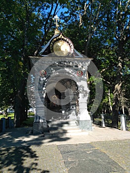 marble chapel with the icon of the Virgin Mary surrounded by green trees