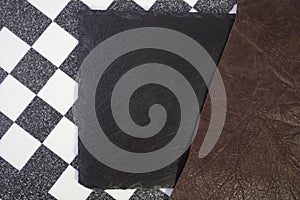 Marble chess board, black stone tile and brown leather, different textures with copy space