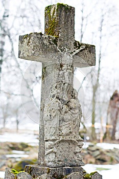 Marble cross on tomb at winter