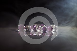 Marble crystal clear ball, rainbow multicolored glitter sparkles background. Selective focus. Multicolored