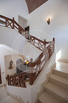 Marble staircase in luxury villa home with wooden bannister photo