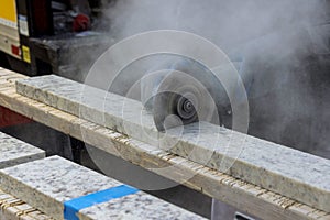 Marble cutting at construction site close up industrial tool, grinder cutting piece of granite stone.