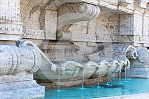 Marble fountain with blue water in Rome, Italy