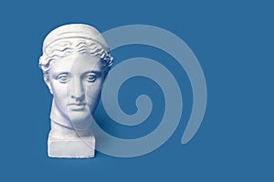 Marble head of young woman, ancient Greek goddess bust isolated on pink background. Gypsum copy of a statue Diana head