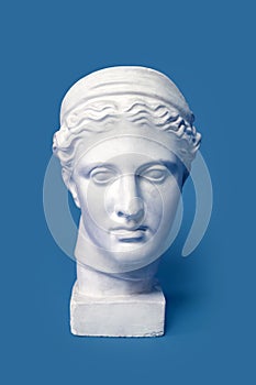 Marble head of young woman, ancient Greek goddess bust isolated on pink background. Gypsum copy of a statue Diana head