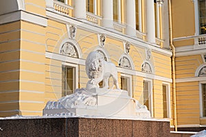 Marble lion holds up the paw core, near the entrance of the State Russian Museum Mikhailovsky Palace, Saint Petersburg, Russia