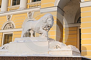 Marble lion holds up the paw core, near the entrance of the State Russian Museum Mikhailovsky Palace, Saint Petersburg, Russia