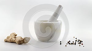 Marble mortar composition with ginger root and white, red and black pepper on a white background