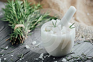 Marble mortar for spices, salt, olive oil and sprigs of rosemary on a wooden cutting board